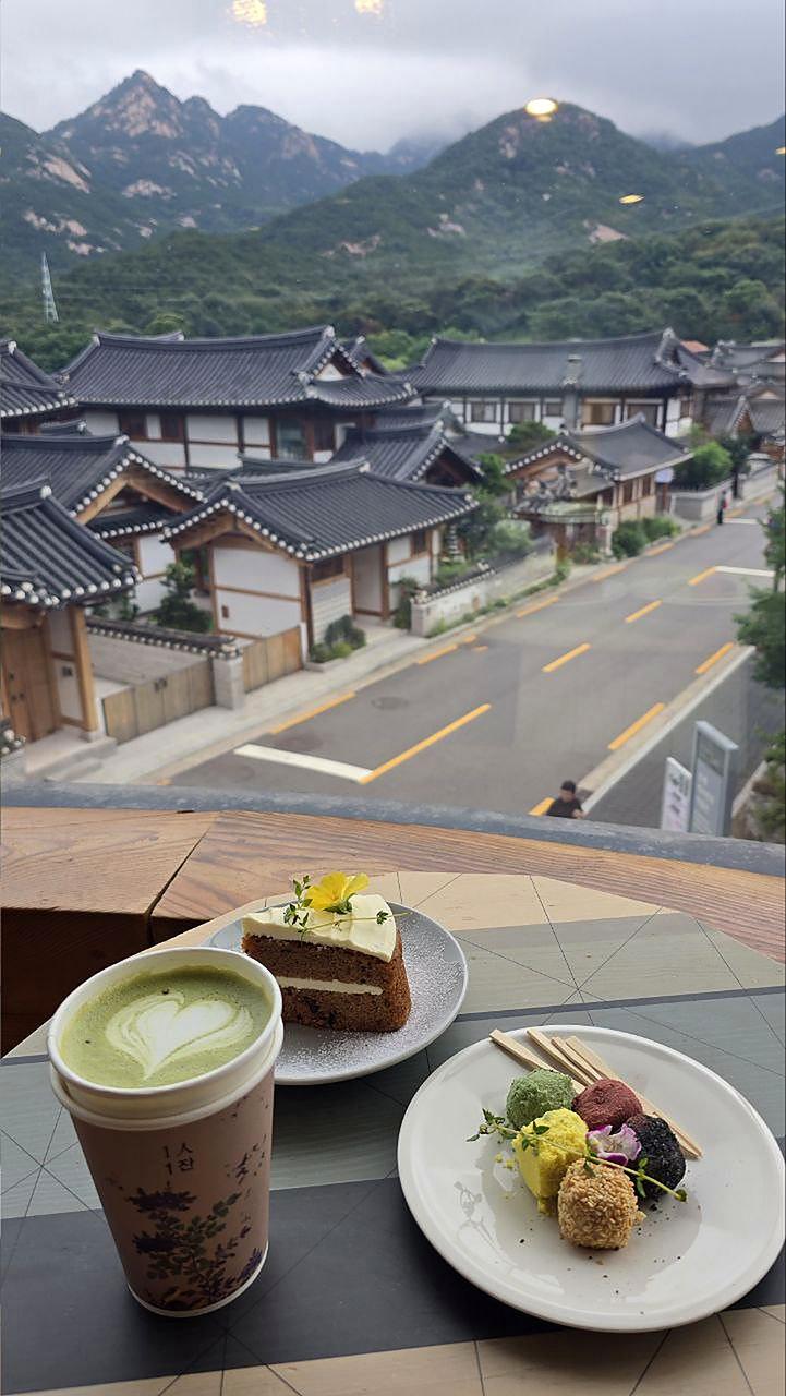 Drinks and desserts on a window table overlooking Eunpyeong Hanok Village
