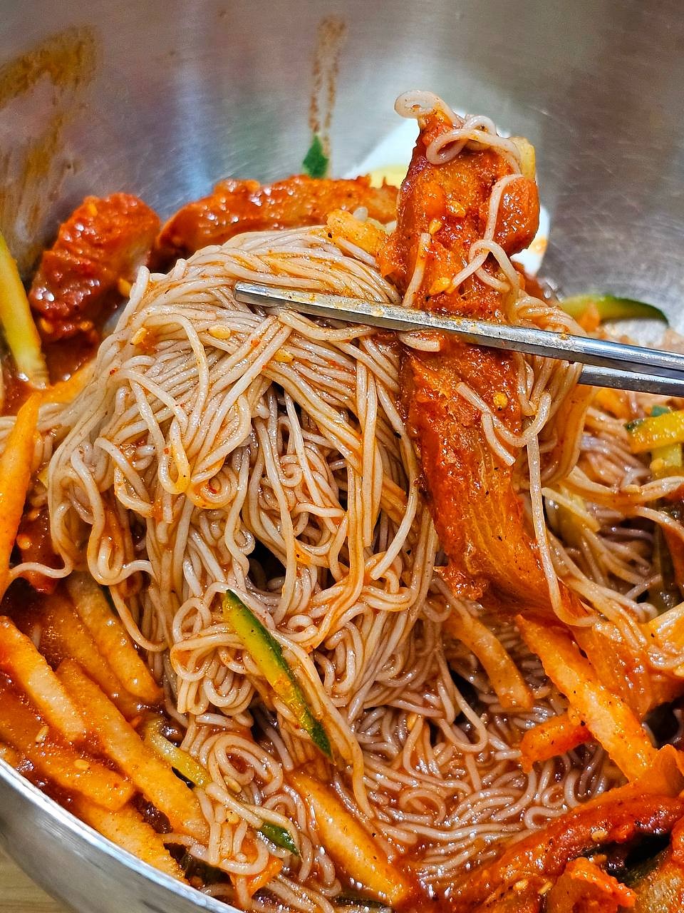 筷子夹起的辣味冷面