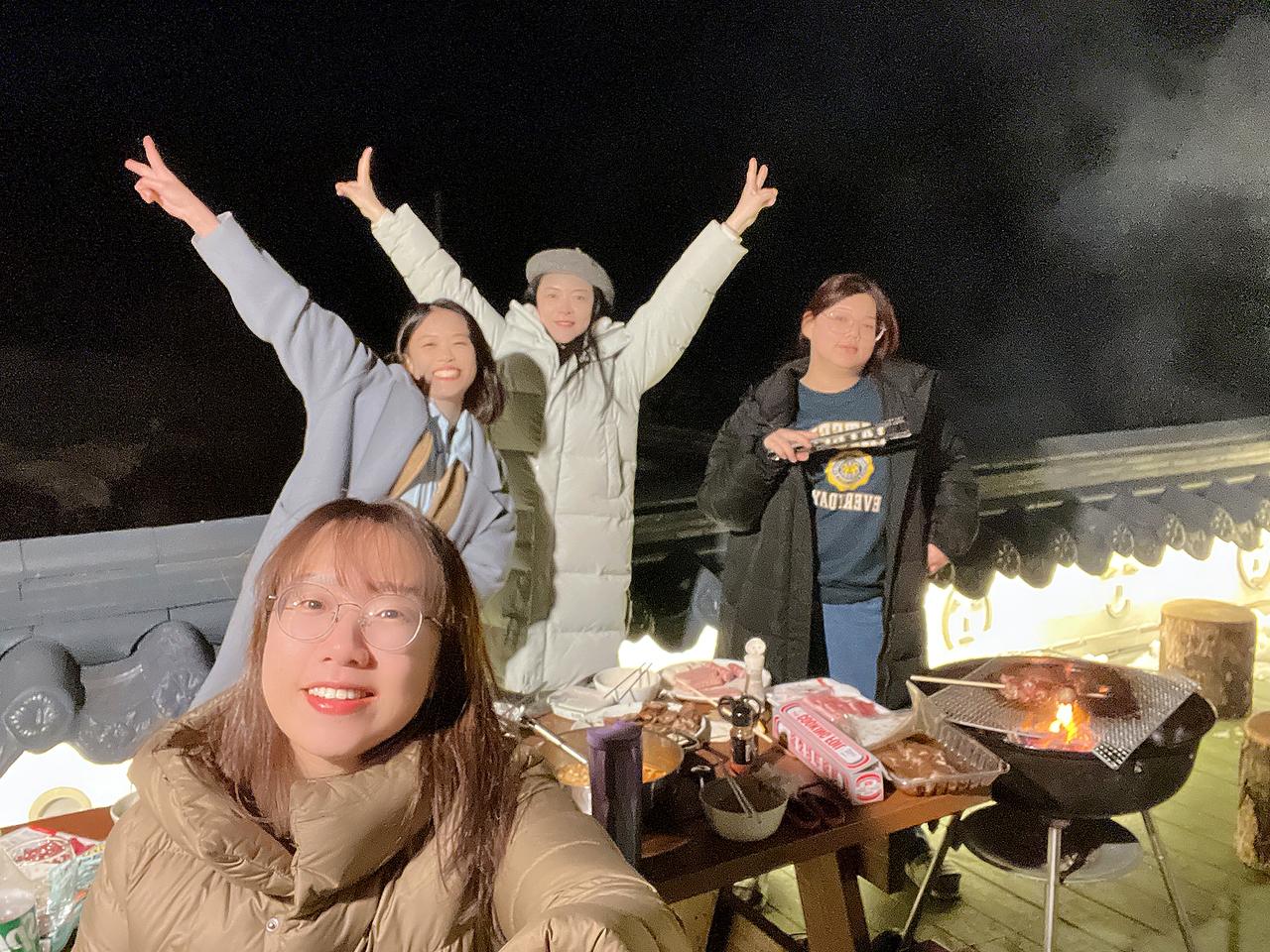 朋友围坐户外烤肉炉共享晚餐