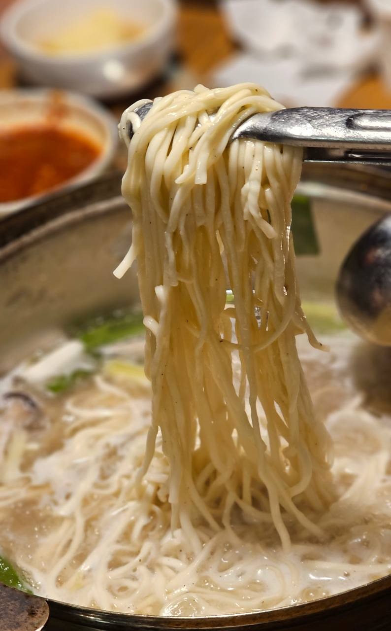 从鸡汤中夹起的面条