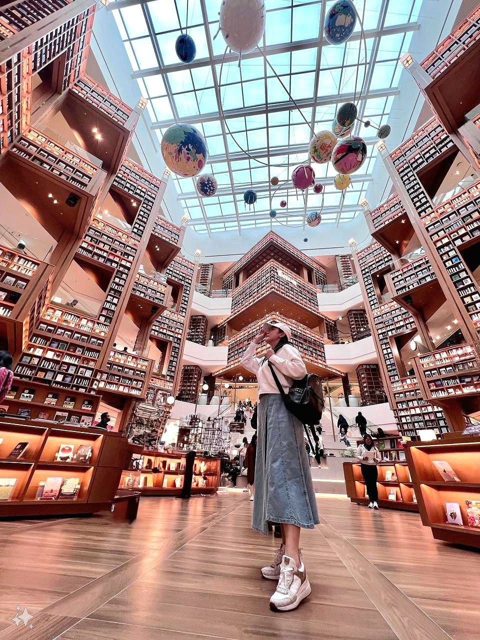 Ms Karyl in front of the bookshelves at Byeolmadang Library Starfield Suwon